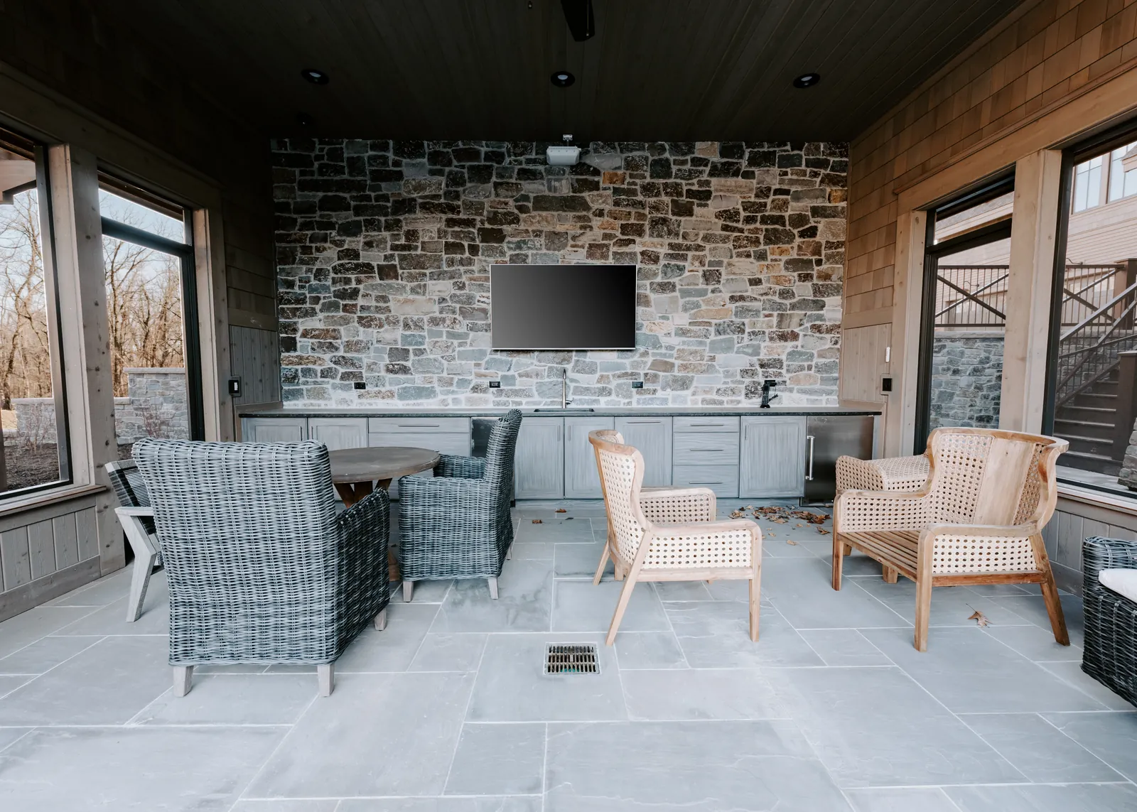 Covered outdoor living area with integrated entertainment system